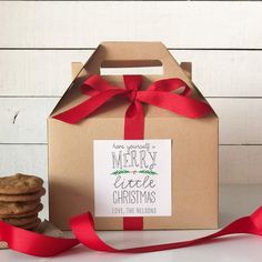 a box that has some cookies in it and a red ribbon on the top of it