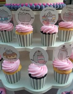 cupcakes with pink frosting and pushers on them are arranged in a tiered display