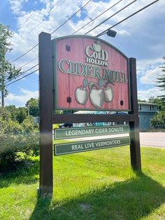 the sign for cider mill is in front of some power lines and trees,