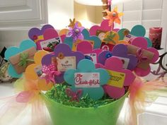 a green bucket filled with lots of colorful hearts and name tags on top of a table