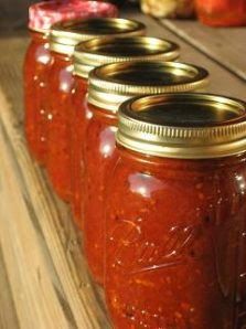 four jars are lined up on a table