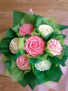 pink and white flowers are arranged on green paper