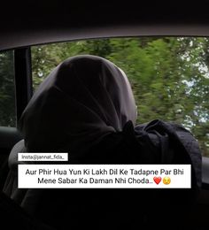 a person in a car looking out the window at some trees and bushes behind them