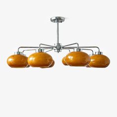 three lights hanging from a ceiling fixture in an industrial - style lighting fixture with five shades of yellow