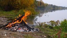 a campfire is lit on the shore of a lake