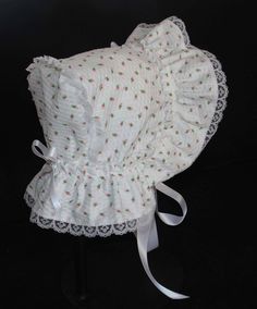 A beautiful Victorian style baby bonnet. Fabric is white searsucker with rosebuds. Lining is white . Bonnet has an extended back and is trimmed with white lace. Bows and extra long ties are made of white double sided satin ribbon. Size/ Measurement from under ear lobe around top of head to under other ear lobe preemie / 10 inches 0-3 months / 11 inches 3-6 months / 12 inches 6-9 months / 13 inches 9-12 months / 14 inches 12-18 months/ 15 inches Fitted White Bonnet With Lace Trim, Adjustable Cotton Bonnet With Lace Trim, White Fitted Hat With Lace Trim, Fitted Cotton Bonnet With Lace Trim, Cute Fitted White Bonnet, Cute White Fitted Bonnet, White Fitted Vintage Bonnet, White Bonnet, Newborn Bonnet