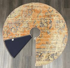 an orange and blue area rug with a triangle on the middle, laying on a wood floor