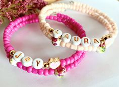 This Custom word bracelet is a very nice gift for those women in your life who loves bracelets. Made with memory wire, this bracelet fits any wrist.  The seed beads are glass beads, 4 mm in size. letters are 6 mm in size. pink ceramic beads are 6 mm. it comes with a little metal pink heart. Good quality beads.  how to order: choose the colour you would like the bracelet. then, on the personalization box, write the word you would like to be on the bracelet. Beads are white with golden letters. Co Jubilee Bracelet With Round Beads As Gift, Jubilee Charm Bracelet With Round Beads As A Gift, Personalized Charm Bracelet Gift, Gift Jubilee Charm Bracelet With Round Beads, Adjustable Jubilee Stretch Bracelet As Gift, Customized Pink Friendship Bracelets For Mother's Day, Valentine's Day Gift Stretch Bracelet With Letter Beads, Customized Adjustable Pink Bracelet, Valentine's Day Gift Letter Beads Stretch Bracelet