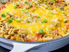 a casserole dish with meat, cheese and green onions