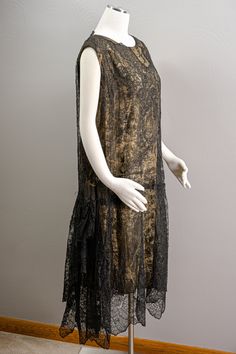 "This is an amazing piece of opulent 20s fashion. This is a 20s evening dress made of beautiful and delicate black Chantilly lace that's over the most jaw-dropping, absolutely stunning gold brocade lame. The lame has beautiful hydrangea flowers woven into it. The dress style is the 20s shift dress that hangs loose about the figure. The first layer of the dress is the gold lame in the shift style. Over the top of the lame is the lace layer that also hangs loose until it is gathered in the back to Black Art Deco Formal Dress, Black Art Deco Flapper Dress For Evening, 1920s Black Flapper Dress For Evening, Black Art Deco Wedding Dress, 1920s Black Flapper Dress For Wedding, 1920s Style Black Flapper Dress For Wedding, 1920s Evening Dress, Handkerchief Style, The 20s