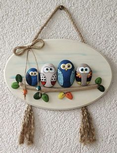 three owls are sitting on a branch with tassels