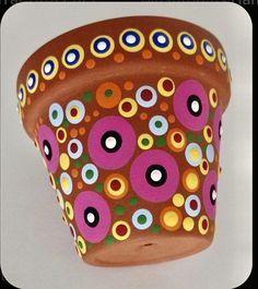 a pot that is sitting on a table with circles painted on the side of it