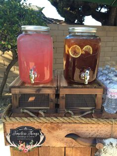 two mason jars filled with liquid sitting on top of a wooden crate