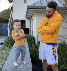 a man standing next to a little boy