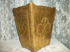 an old wooden box sitting on top of a white tablecloth covered table with lace