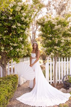 a woman in a white dress holding an umbrella