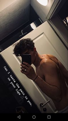 a shirtless man taking a selfie in front of a mirror with his cell phone