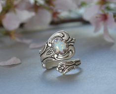 THE ORIGINAL OPAL SPOON STYLE RING D E S C R I P T I O N This stunning spoon style ring features a 7mm shimmering lab created white opal. Such a pretty ring, the opals has little flecks of colors including red, yellow, blue and green. The ring looks great on any finger or wear it on your thumb for a unique boho vibe. What more could a girl want? The spoon ring setting is brass based and silver plated. The ring is new, cast from vintage dies that date back to the mid-century era when spoon rings Opal Promise Ring, October Birthstone Rings, White Opal Ring, Spoon Ring, Spoon Jewelry, Fire Opal Ring, Spoon Rings, Trendy Ring, Meaningful Jewelry