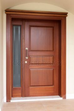 a wooden door in front of a white wall