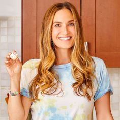 a woman in a kitchen holding a donut