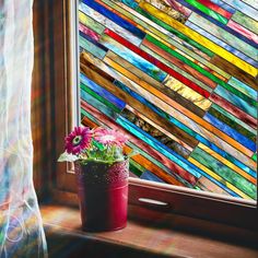 a potted plant sitting on top of a window sill next to a stained glass wall