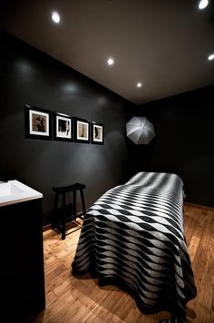 a bedroom with black walls and pictures on the wall