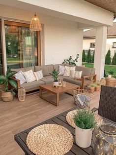 an outdoor living area with wicker furniture and potted plants