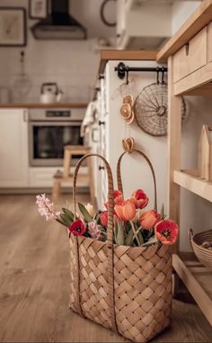 two baskets filled with flowers sitting on top of a wooden floor next to an oven