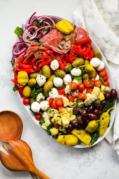 a salad with olives, tomatoes, red onions and other vegetables