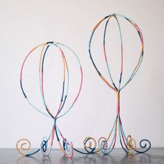 two wire sculptures sitting on top of a table