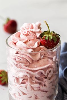 a strawberry cake in a glass with whipped cream and strawberries