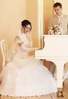 the bride and groom are posing for a photo in front of a white grand piano