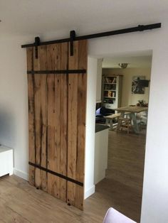 an open sliding door in a living room with hardwood flooring and white painted walls