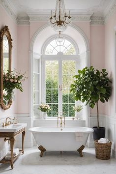 a white bath tub sitting under a window next to a potted plant in a bathroom