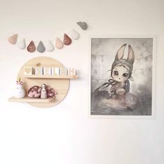 a white wall with some shelves and pictures on the wall next to it is an art piece