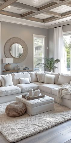 a living room filled with white furniture and lots of pillows on top of a rug