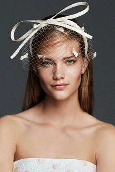 a woman in a white dress with a veil over her head and butterflies on it