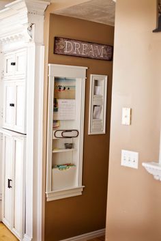 a white refrigerator freezer sitting inside of a kitchen next to a wall mounted sign