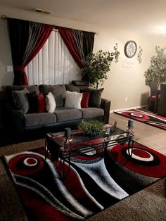 a living room filled with furniture and a red rug on top of a carpeted floor