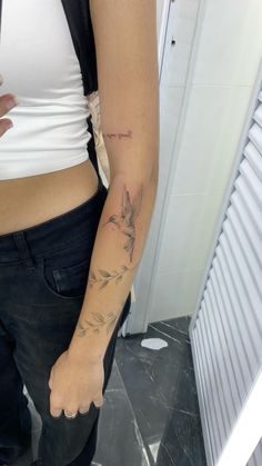 a woman's arm with a bird tattoo on the left side of her body