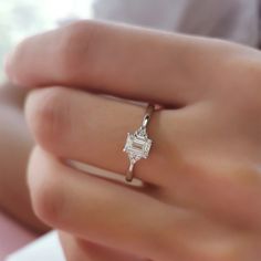 a woman's hand with a diamond ring on it