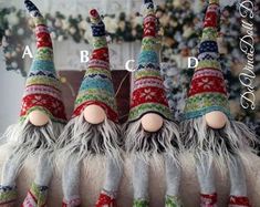 three knitted gnomes are sitting on top of each other