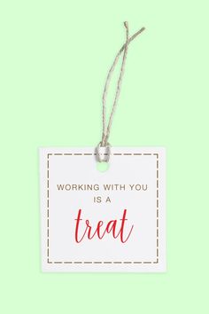 a white sign with the words working with you is a treat hanging from a string