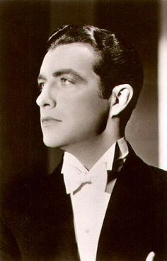 an old photo of a man in a tuxedo and bow tie looking off to the side