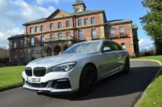 a silver car parked in front of a large building