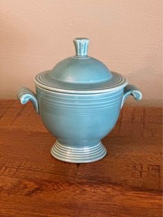 a blue pot sitting on top of a wooden table