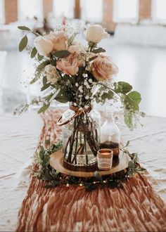 an arrangement of flowers and candles on a table