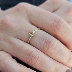 a close up of a person's hand with a gold ring on it and diamonds