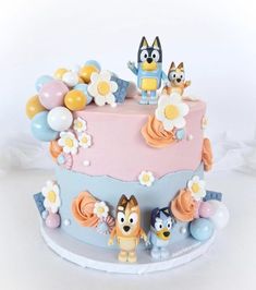 a cake decorated with cartoon characters and balloons