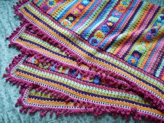 colorful crocheted afghans are laid out on the floor